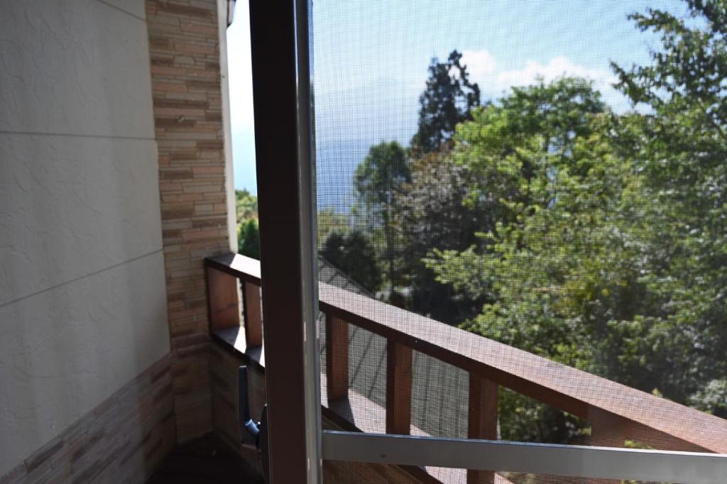 a balcony with a door open to a view of trees at Dreamtown in Ren&#39;ai