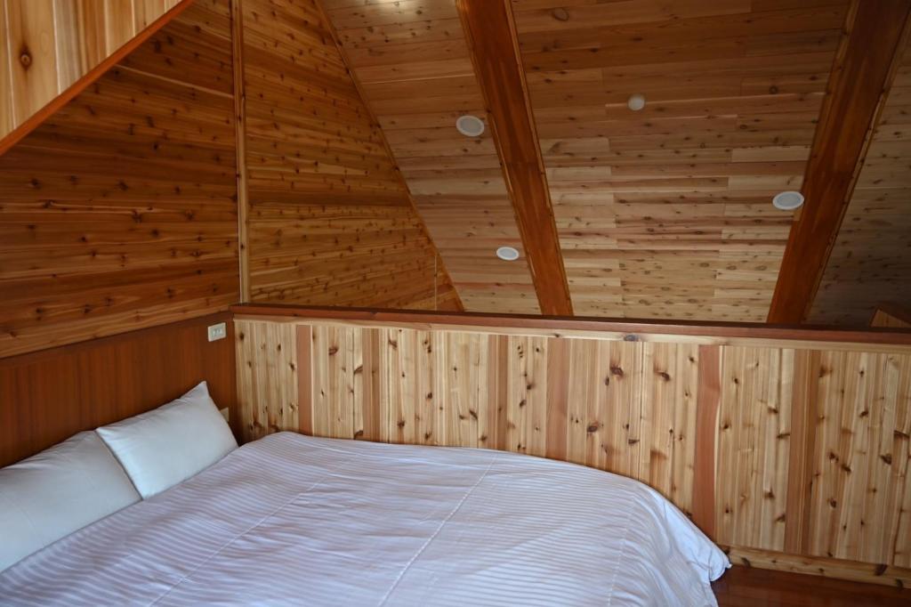a bedroom with a bed in a wooden ceiling at Dreamtown in Ren&#39;ai