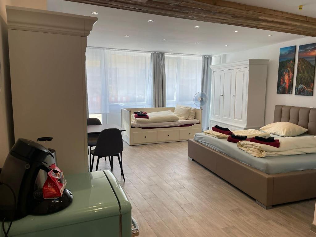 a bedroom with two beds and a table and a chair at Ferienwohnung Beutelsbacherstr. 12 B in Stuttgart