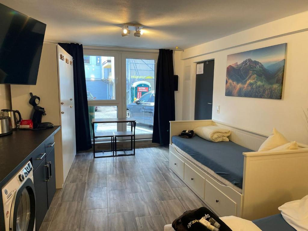 um pequeno quarto com uma cama e uma cozinha em Ferienwohnung Beutelsbacherstr. 12 C em Estugarda