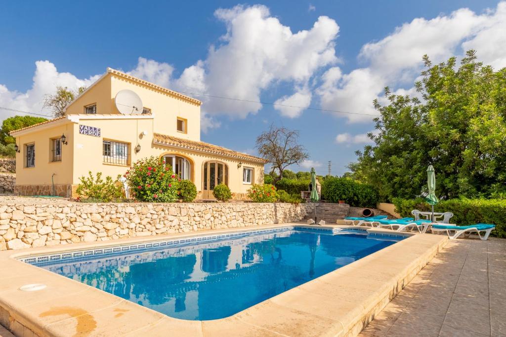 eine Villa mit einem Pool vor einem Haus in der Unterkunft Tranquil Restored Farmhouse in Benitatxell