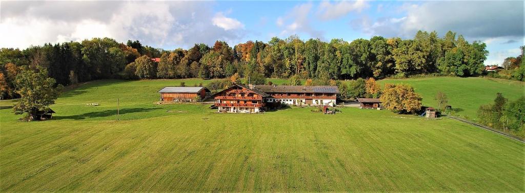 eine Luftansicht eines Hauses auf einem großen grünen Feld in der Unterkunft Georgihof Ferienwohnungen in Murnau am Staffelsee