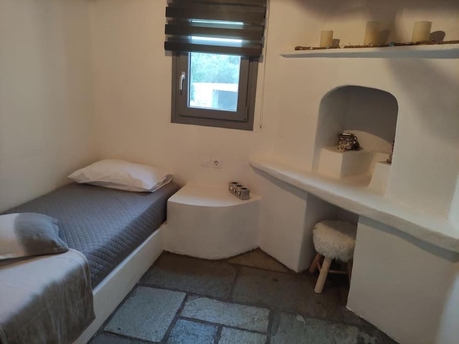 Dormitorio pequeño con cama y lavamanos en Villa Elia Ios, en Ios Chora