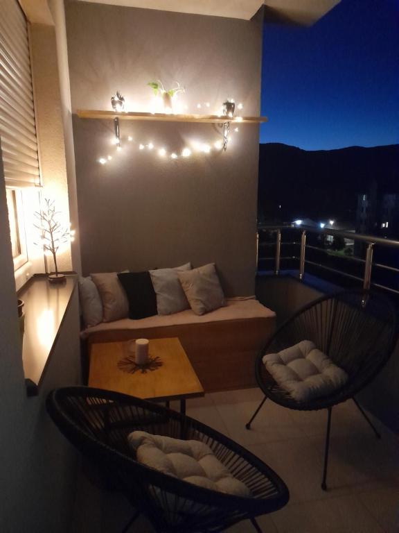 einen Balkon mit einem Sofa, 2 Stühlen und einem Tisch in der Unterkunft GRAND BB Apartman in Bajina Bašta