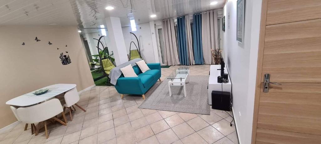 ein Wohnzimmer mit einem blauen Sofa und einem Tisch in der Unterkunft Le soleil couchant in Le Tampon