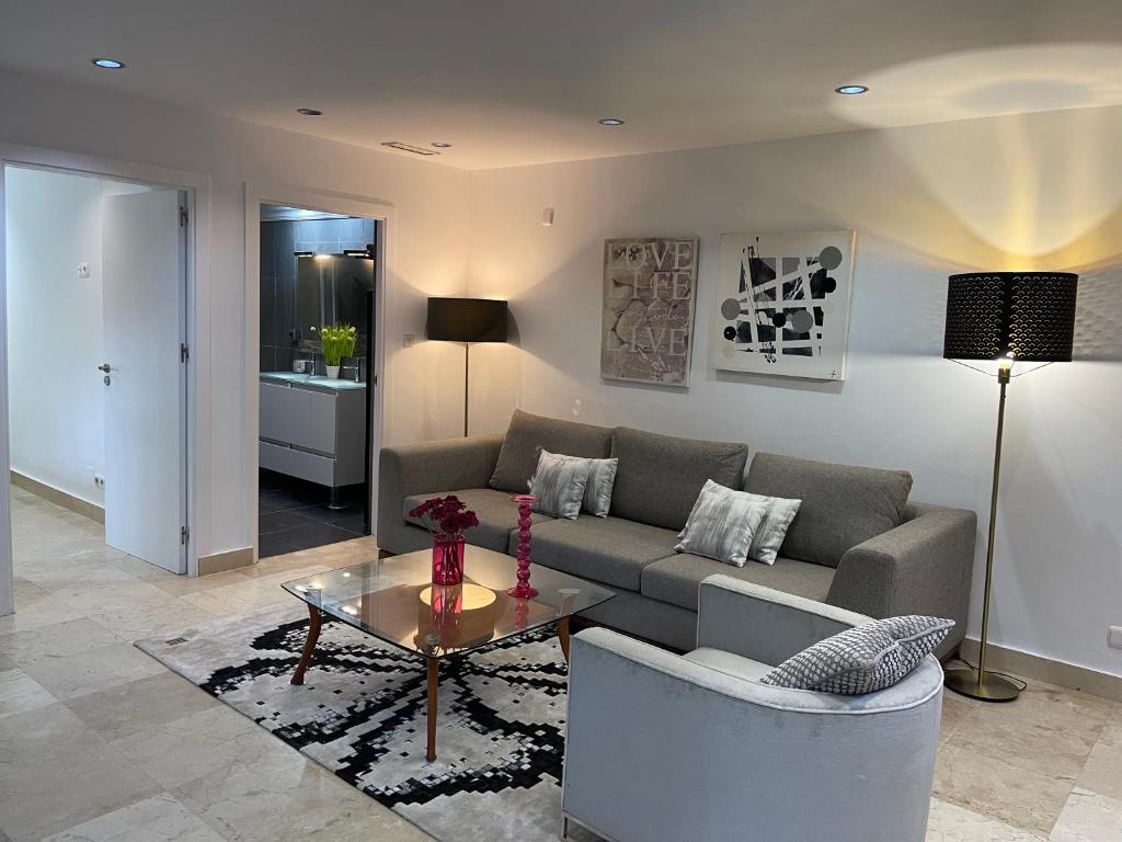 ein Wohnzimmer mit einem Sofa und einem Tisch in der Unterkunft PUERTO BANUS Apartamento LOLA in Marbella