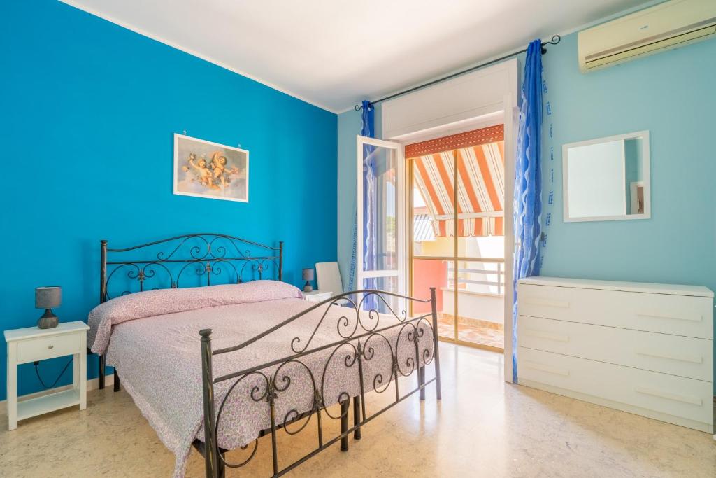 1 dormitorio con paredes azules y 1 cama en Appartamento Relax Gallipoli, en Gallipoli