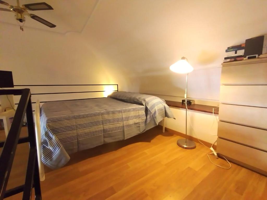 Dormitorio pequeño con cama y lámpara en Casa di Grazia, en Isquia