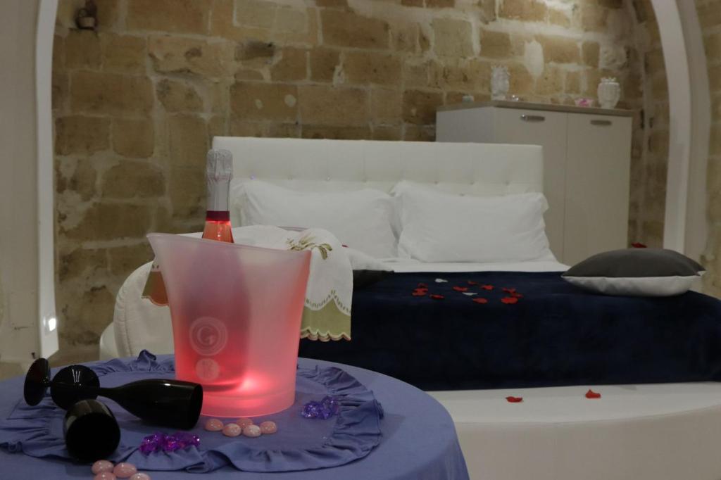 ein Schlafzimmer mit einem Bett und einem Tisch mit einem Getränk darauf in der Unterkunft Relax Santa Cecilia in Gravina in Puglia