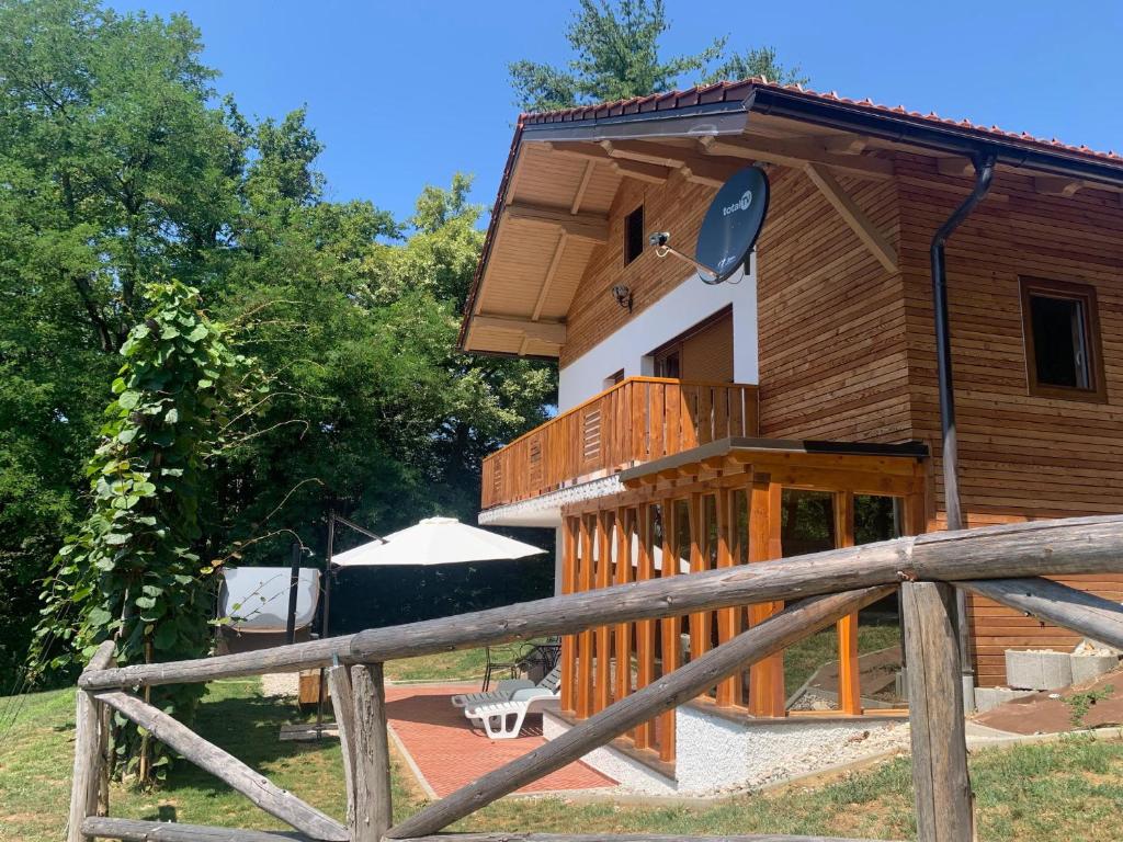 une cabane en bois avec une véranda et une clôture dans l'établissement Holiday Home Liberg with Hot tub and Sauna, à Brežice