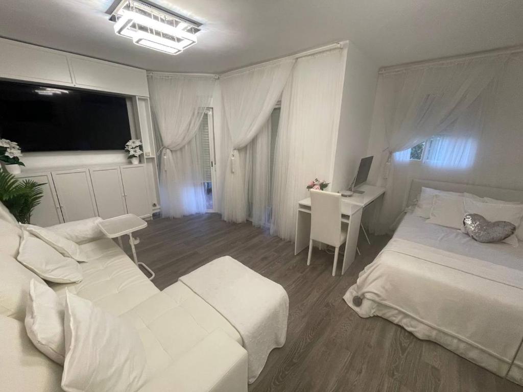 biała sypialnia z łóżkiem i biurkiem z komputerem w obiekcie LUXURY room en MADRID w Madrycie
