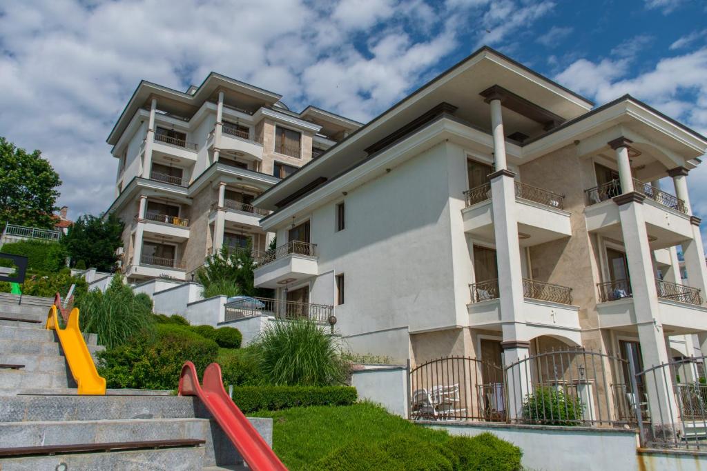 a large apartment building with a playground in front of it at Paraiso Theopolis - All Inclusive in Obzor