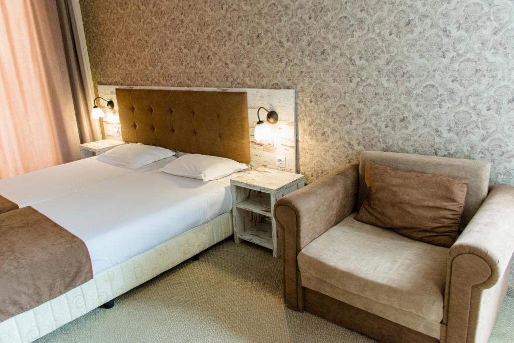 a hotel room with a bed and a chair at Paraiso Theopolis - All Inclusive in Obzor