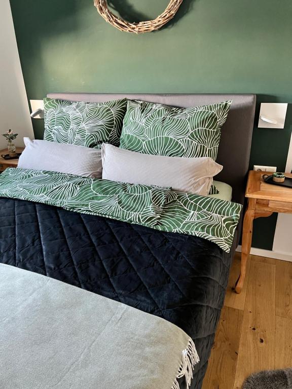 a bed with green and white pillows on it at BeeHome Euskirchen in Euskirchen