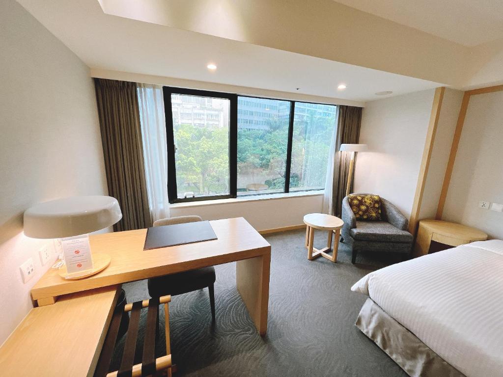 a hotel room with a desk and a bed at Sonnien Hotel in Taipei