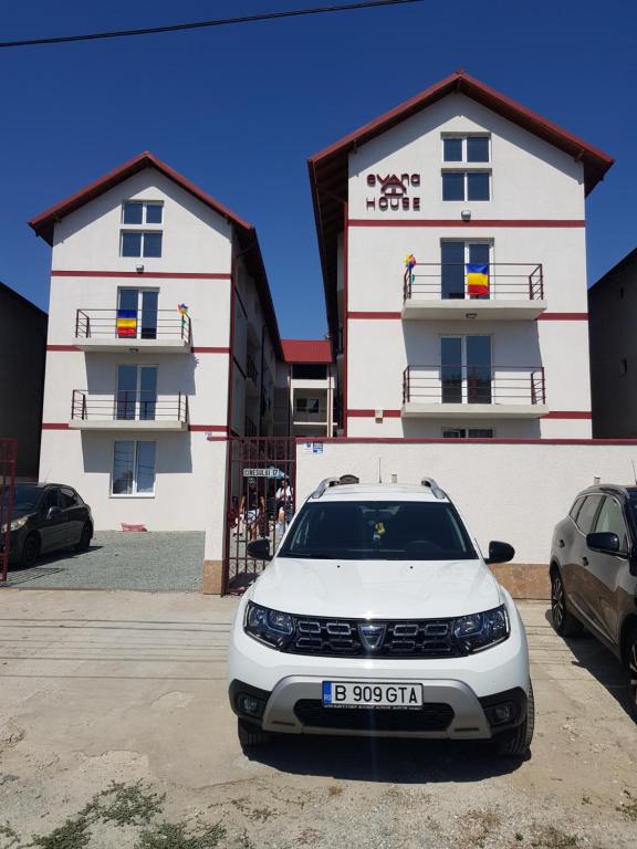 um carro branco estacionado em frente a um edifício em EVANA HOUSE em Costinesti