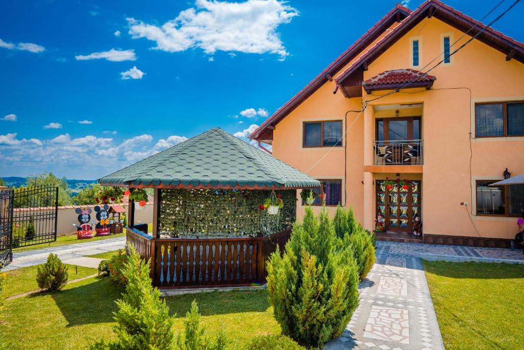 ein Haus mit einem Pavillon im Hof in der Unterkunft Pensiunea Adrian in Novaci-Străini