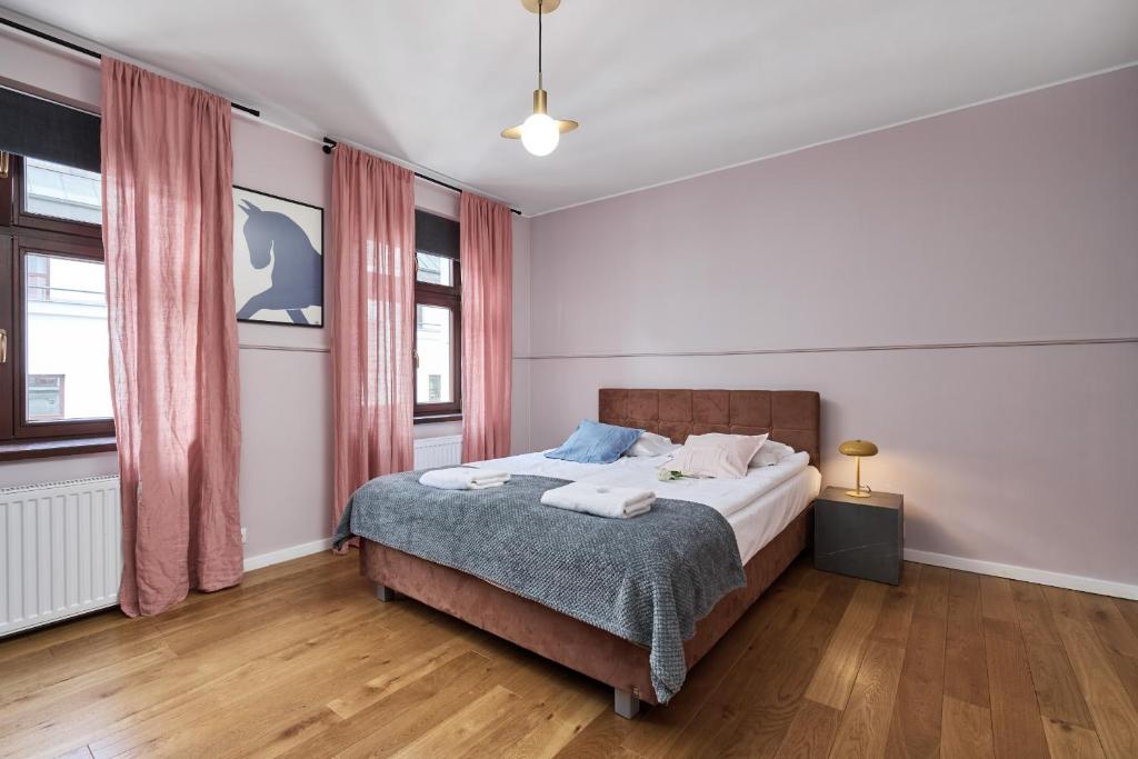 a bedroom with a bed and two windows at Heart of Wroclaw Uniwersytecka by Renters in Wrocław