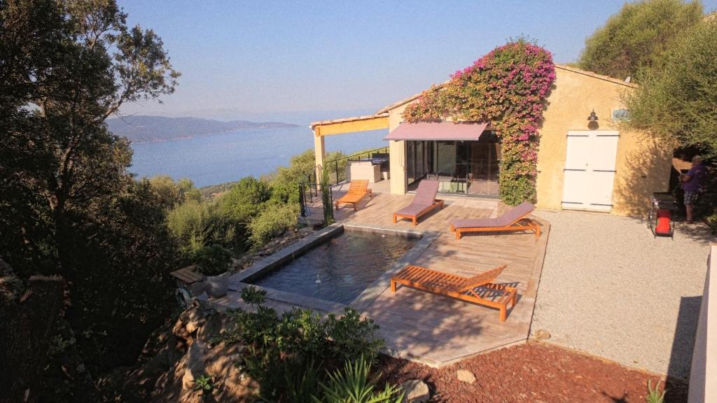 a house with a swimming pool with a view of the water at Villa CALANCA - Domaine La Raggia in Olmeto