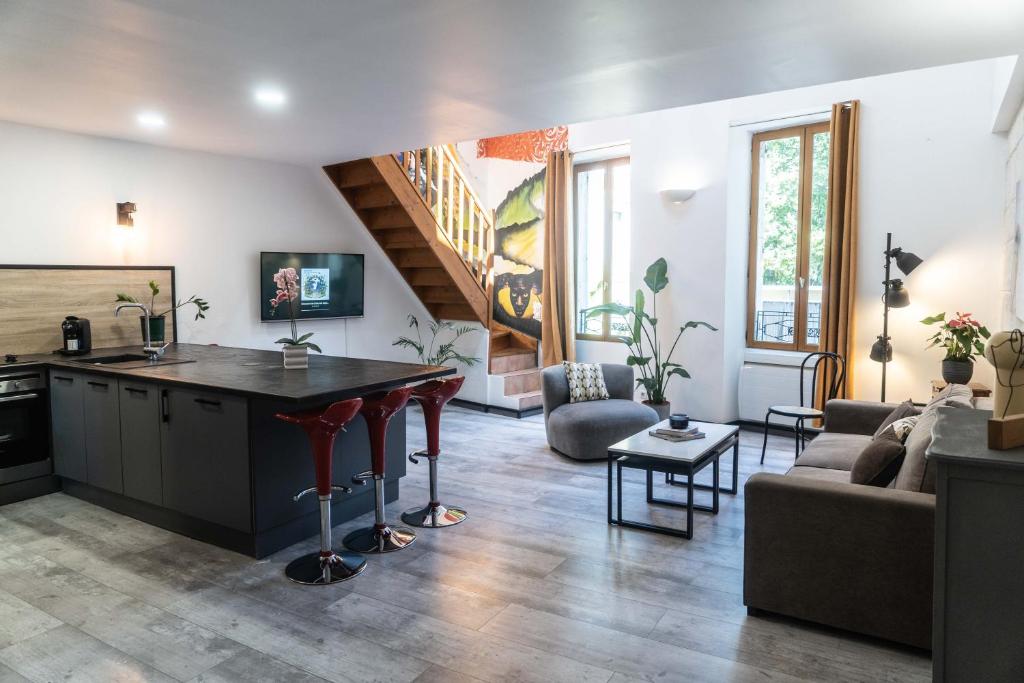 een keuken en woonkamer met een tafel en een bank bij Duplex Street-Art Centre-Ville Netflix Disney by Rentabao in Avignon