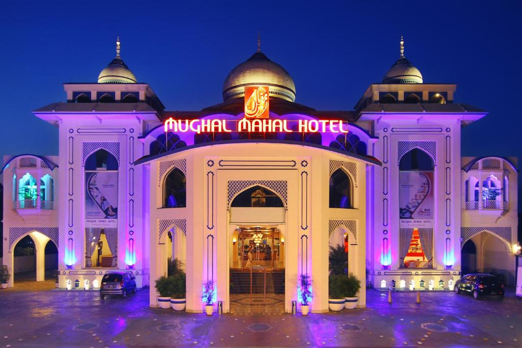 Gujrānwāla的住宿－MUGHAL MAHAL HOTEL，akritkrit市场酒店在晚上点燃了照明。