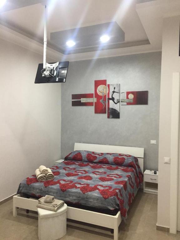a bedroom with a bed and some pictures on the wall at Berenice Suite in Taranto