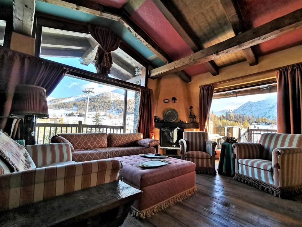 a living room with couches and a view of a mountain at Hostdomus - Imperial Chalet in Sestriere