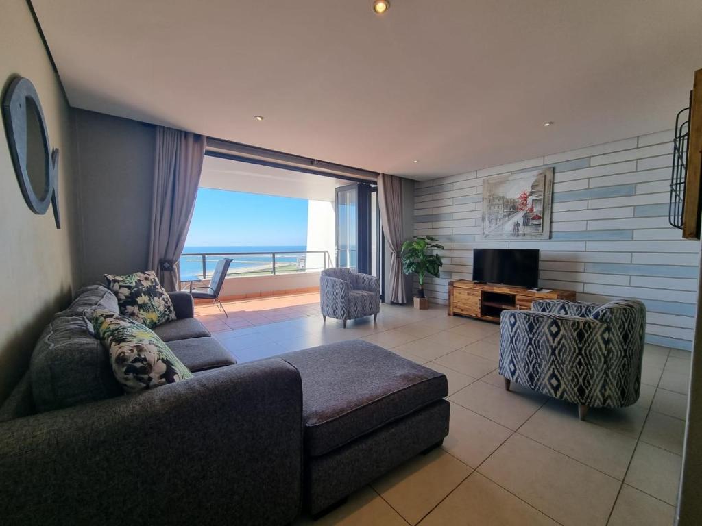 a living room with a couch and a view of the ocean at Accommodation Front - Immaculate 4 Sleeper with Ocean & Harbour Views in Durban