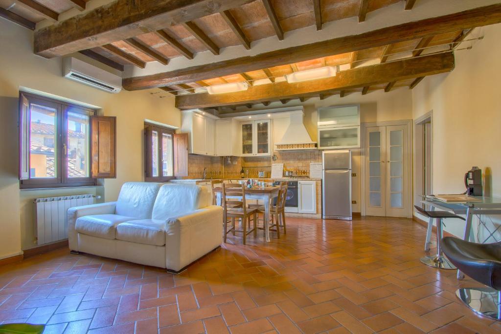a living room with a couch and a kitchen at APPARTAMENTO SULLA SALA in Pistoia