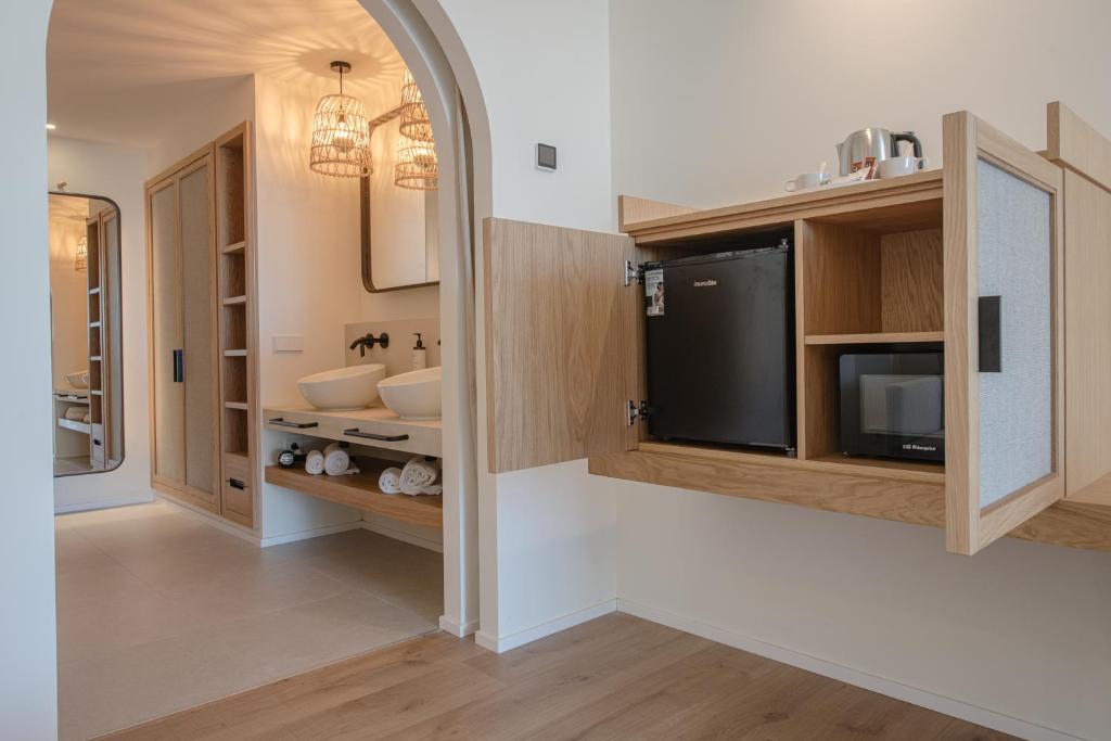 a bathroom with a sink and a tv in a room at Hotel & Spa Blau Parc in San Antonio