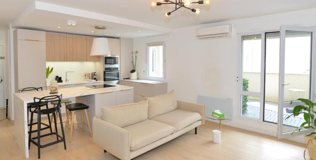 ein Wohnzimmer mit einem Sofa und einer Küche in der Unterkunft Appart'Genevois in Villeurbanne