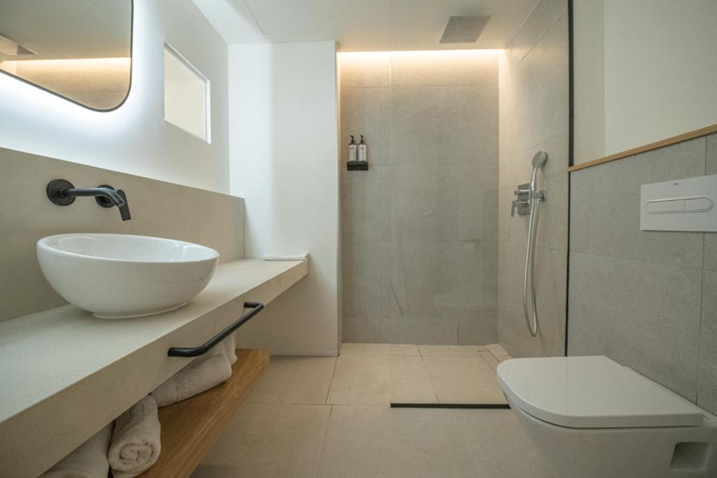 a white bathroom with a sink and a shower at Hotel & Spa Blau Parc in San Antonio