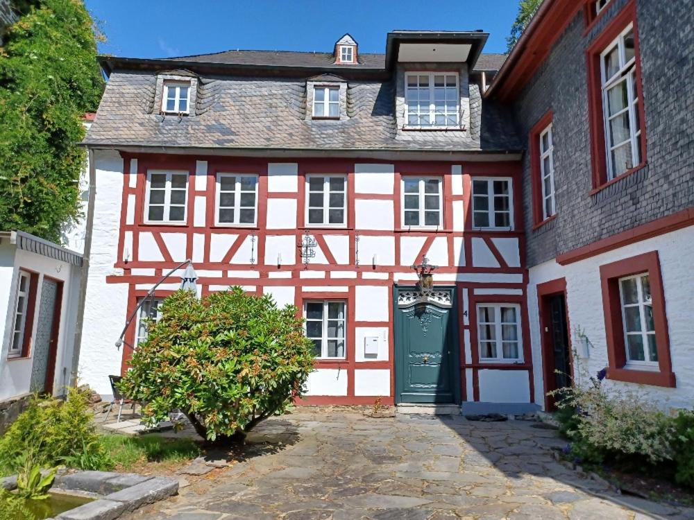 a red and white house with a green door at Felsenkeller - Brauerei in Monschau