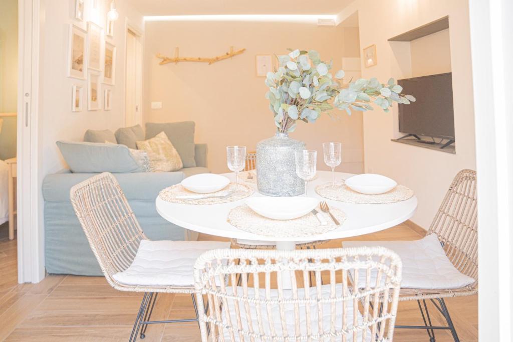 a dining room with a white table and chairs at Moneglia in Piazza in Moneglia