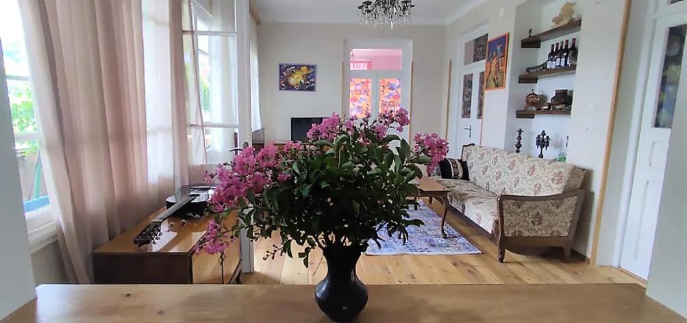a living room with a vase with flowers on a table at Tuta House Sighnaghi in Sighnaghi