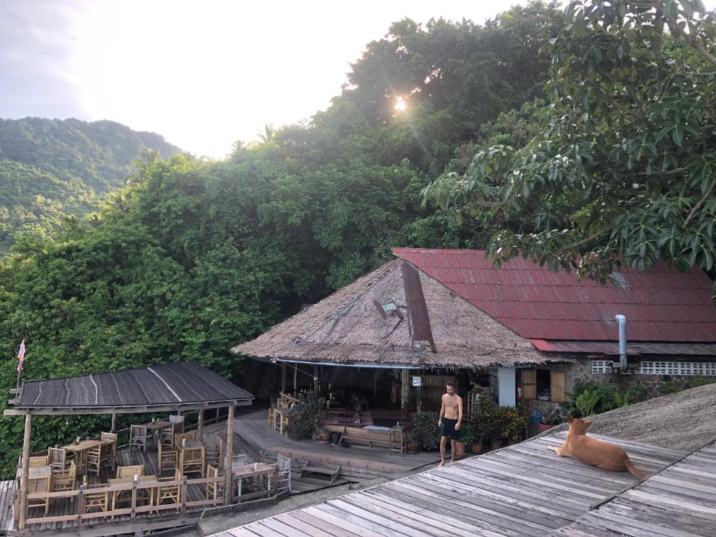 a man standing on top of a building at Bambu Huts in Baan Tai