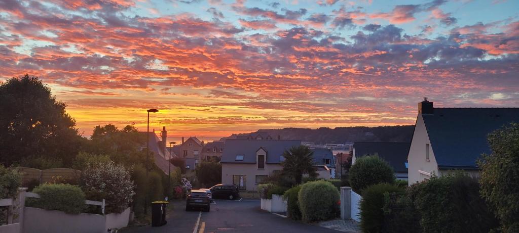 una calle de la ciudad con una puesta de sol en el cielo en Côte et Mer, en Erquy