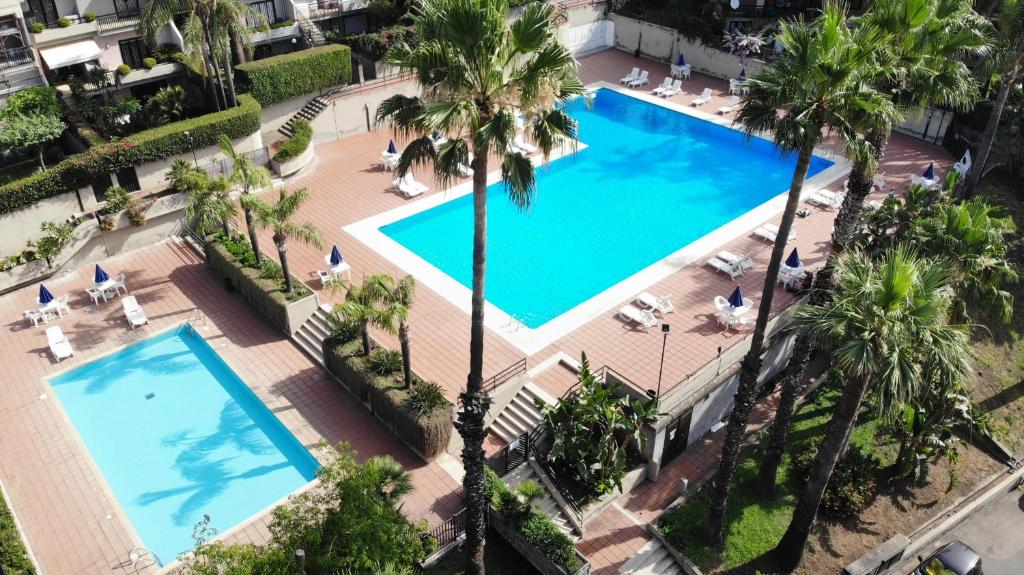 uma vista sobre uma piscina num hotel com palmeiras em Amaranda B&B em Catânia