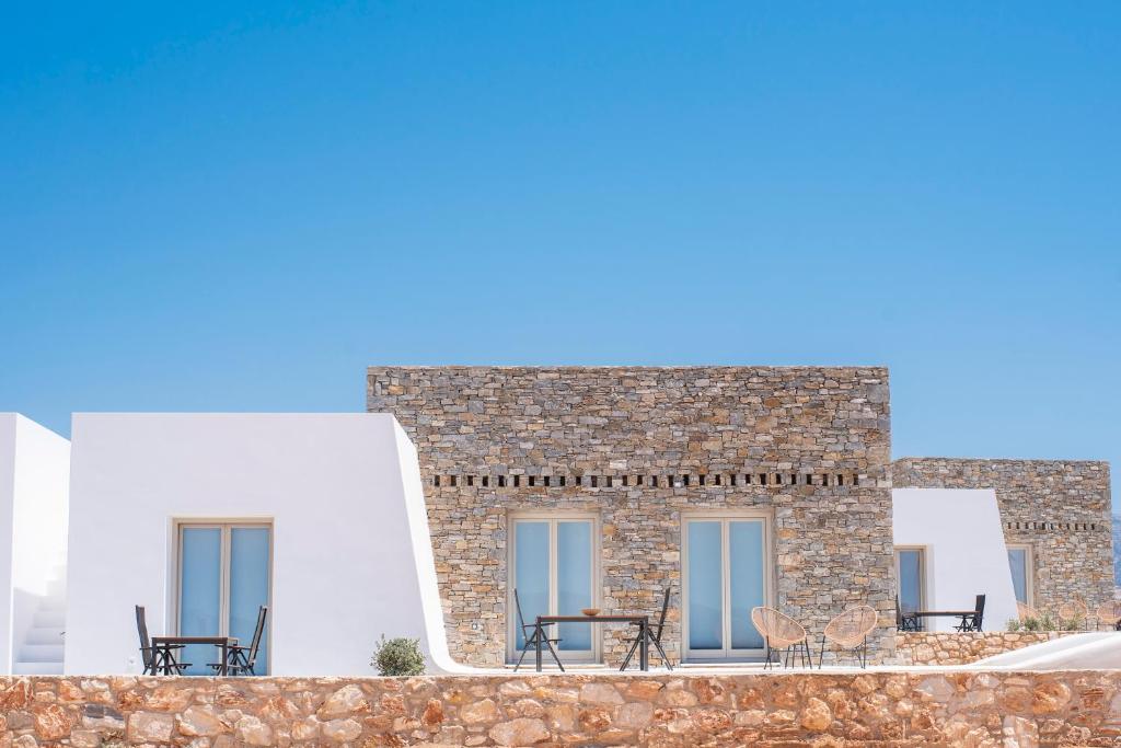 a building with tables and chairs in front of it at CAMPO SUITES in Kampos Paros