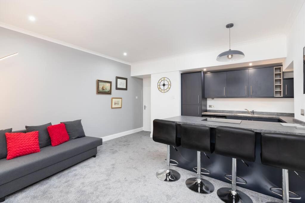 a living room with a couch and a kitchen at City centre 2 bedroom flat with on site parking in Perth