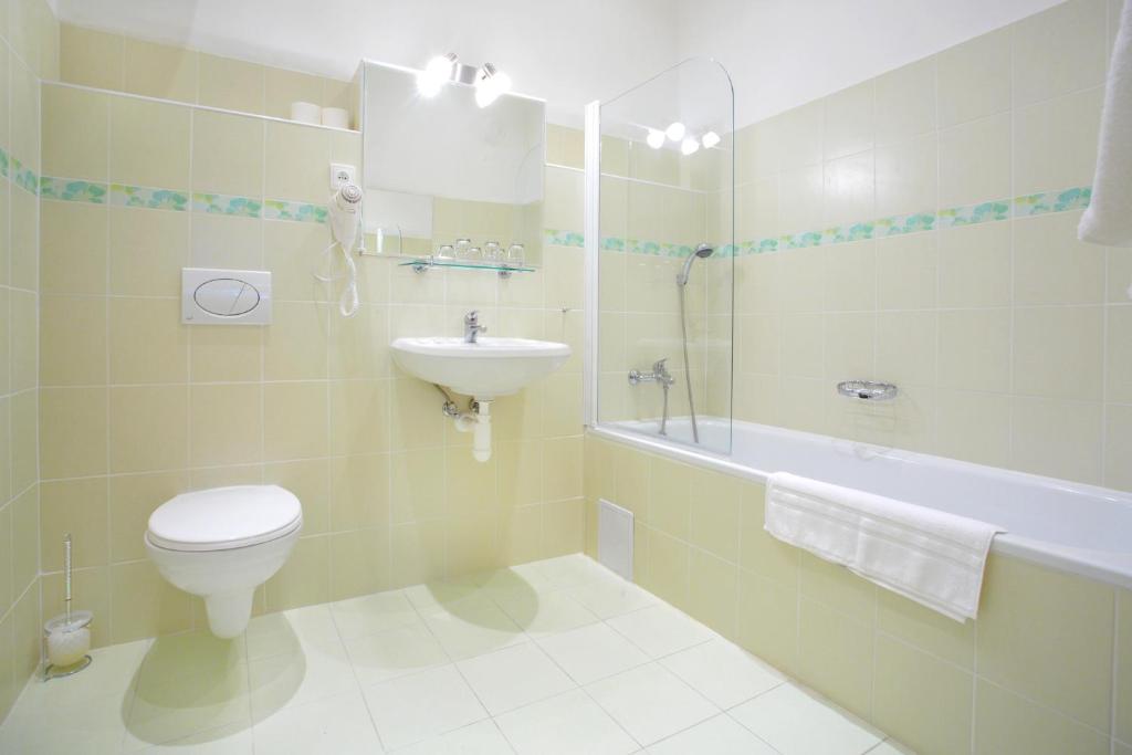 a bathroom with a toilet and a sink and a tub at Wenceslas Square Hotel - Czech Leading Hotels in Prague