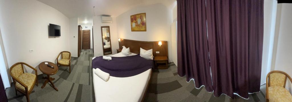 una camera con letto in una stanza con tende viola di Pensiunea View a Cluj-Napoca