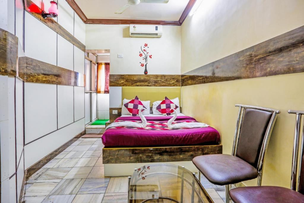 a bedroom with a bed and two chairs at HOTEL GOLDEN PLAZA in Mumbai