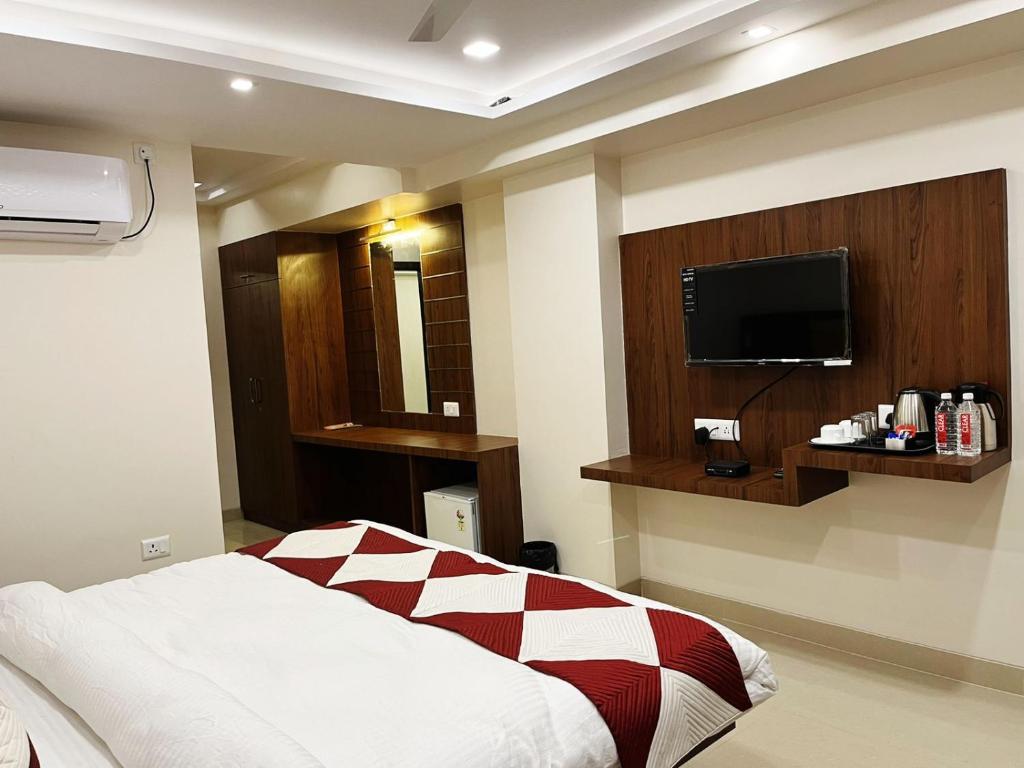 a bedroom with a bed and a flat screen tv at Hotel MK Grand in Varanasi