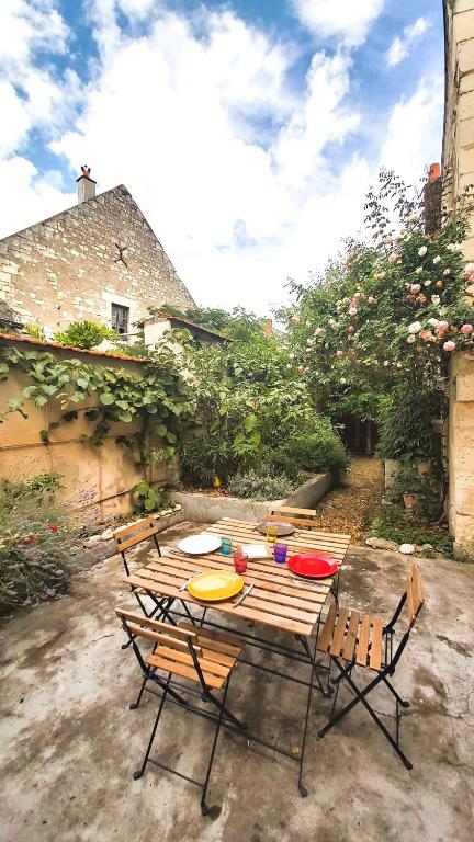 una mesa de picnic con sillas y platos. en La Maison de Louise Chinon #chateaux #vignobles, en Chinon