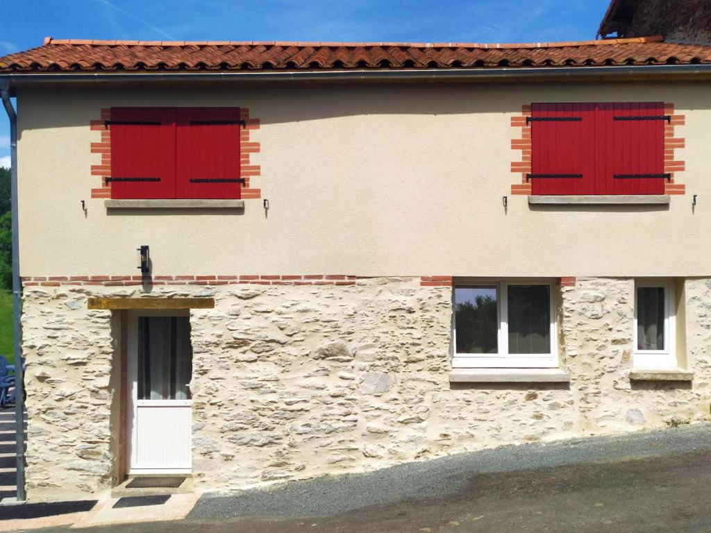 Le BoupèreにあるAu Fil de l'Eauの赤いシャッターが付いた石造りの建物