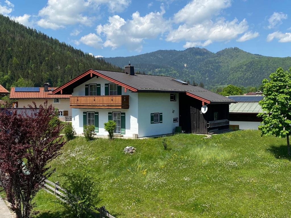 ein Haus auf einem Grashügel in der Unterkunft Ferienwohnung Reich in Schönau am Königssee
