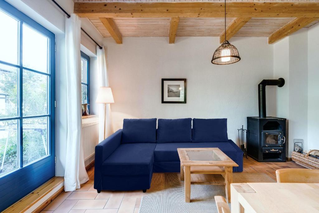 a living room with a blue couch and a wood stove at 3-Raum Apartment bis 6 Pers 42 in Rankwitz