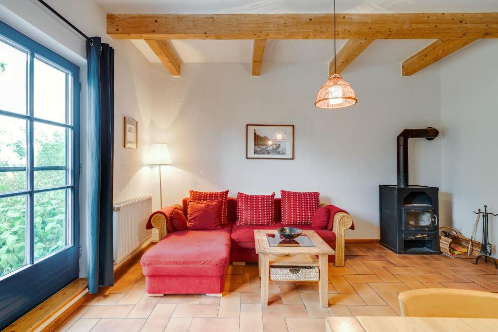 a living room with a red couch and a wood stove at 4-Raum Apartment bis 6 Pers 21 in Rankwitz