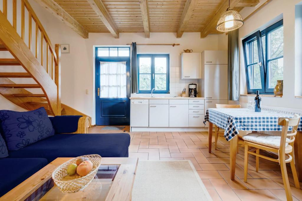 2-Raum Apartment bis 4 Pers 32 في Rankwitz: غرفة معيشة مع أريكة زرقاء وطاولة